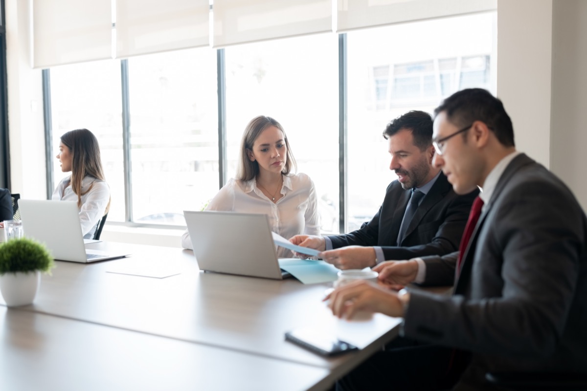 Business team reviewing compliance documents together in a meeting room