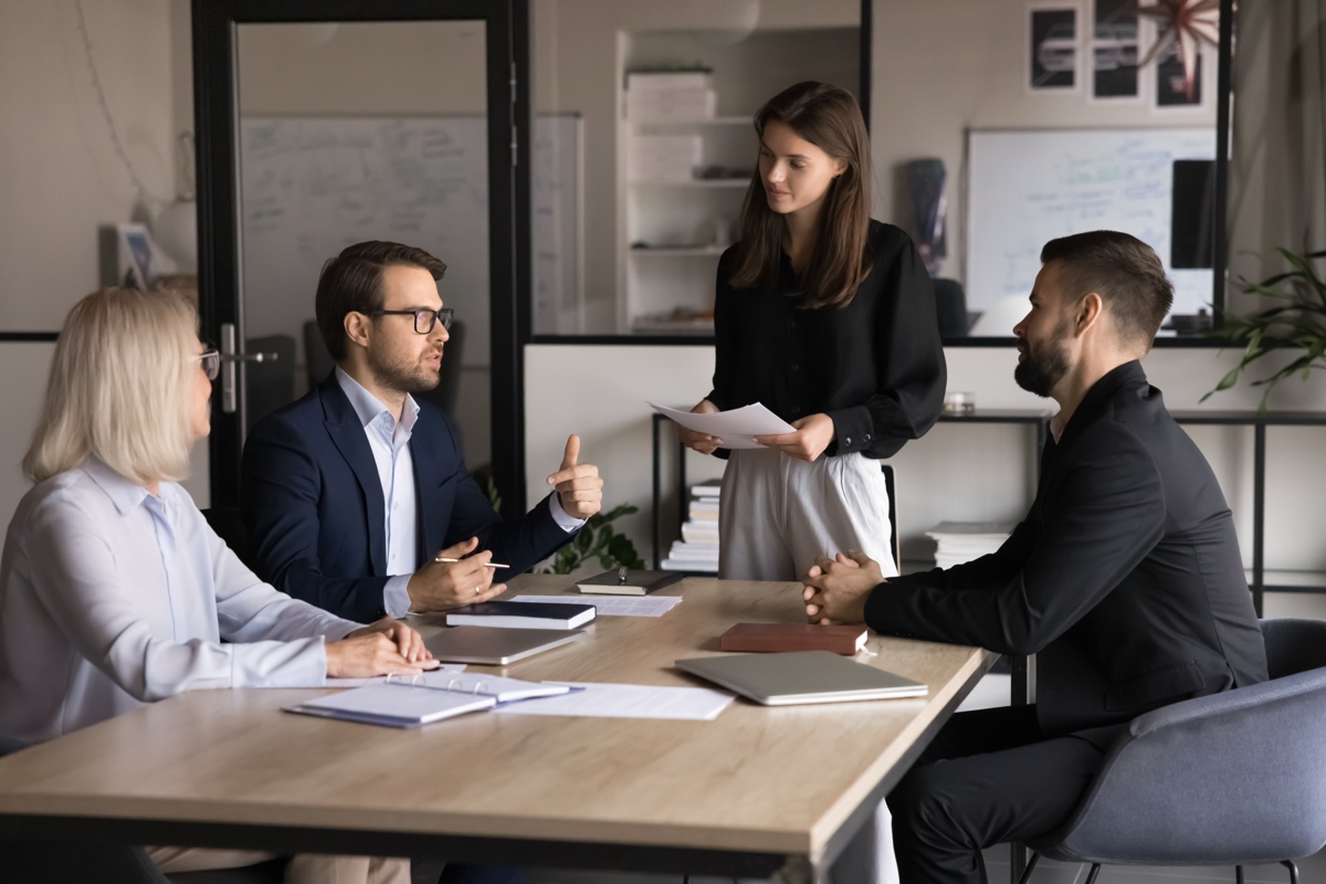 A benefits team reviewing plan cost documents in a conference room